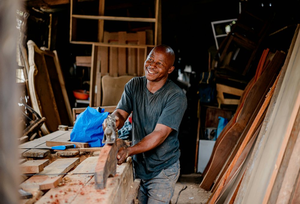 Lächelnder Tischler bei der Arbeit mit Holz