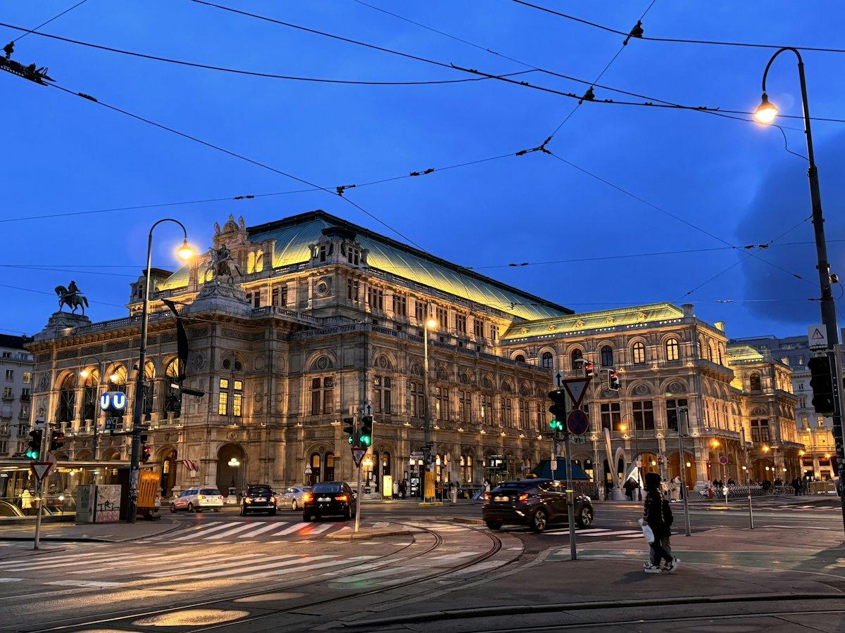 Beleuchtetes Gebäude an einer Straßenecke in Wien am Abend
